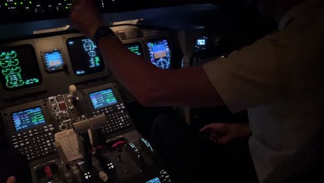 Cockpit-view-at-night-while-flying-copilot-is-preparing-the-jet-for-the-approach-in-a-real-flight