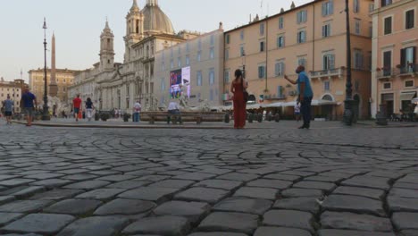 Slow-motion-surface-level-pov-of-famous-Piazza-Navona-square-with-tourists-in-Rome-at-sunset,-first-person-view