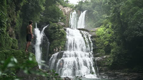 Mann-Schaut-Sich-Um-Mit-Nauyaca-Wasserfällen-Im-Regenwald-Von-Costa-Rica-Im-Hintergrund