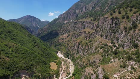 Beautiful-valley-through-rocky-mountains,-river-streaming-on-peaceful-landscape-in-Albania