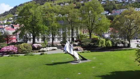 Famous-controversial-statue-of-Olav-Kyrre-in-byparken-Bergen-Norway---Reverse-aerial-from-close-up-to-city-overview