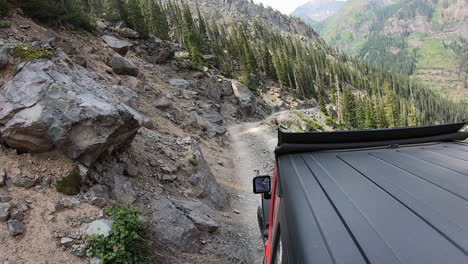 Rooftop-of-4WD-vehicle-creeping-along-narrow-trail-cut-in-mountain-side-above-Poughkeepsie-Gulch-near-Ouray-Colorado