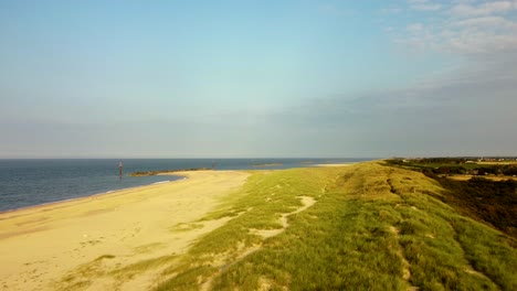 Drohne-Fliegt-über-Wunderschöne-Sanddünen-Und-Meer-An-Einem-Sonnigen-Strand,-Großbritannien