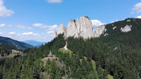 Panorama-Of-The-Lonely-Rock-Rising-Above-Evergreen-Forest-At-Piatra-Singuratica-In-Hasmasul-Mare,-Romania