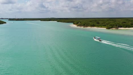 Aerial-view-video-taken-by-drone-of-boat-in-Caribbean-tropical-sand-beach-with-turquoise---sapphire-water,-Rio-Lagartos-lagoon,-Mexico