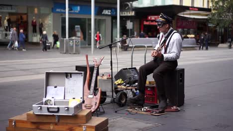 Street-Performer-Artist-Wearing-Captain's-Hat-Busking-with-Electric-Guitar-on-Bourke-Street-City-of-Melbourne-CBD,-Victoria,-Australia