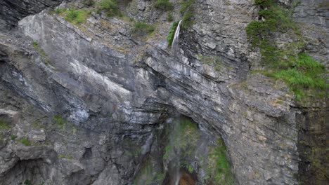 Rocky-slope-splashed-by-water-falling-from-high-peak-of-mountain-in-Albanian-Alps
