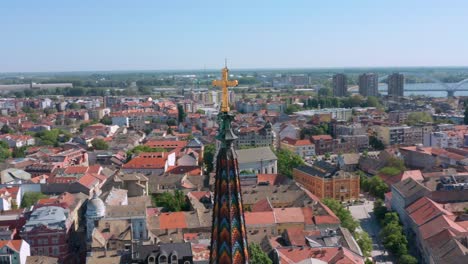 Spire-Of-The-Name-Of-Mary-Church-And-The-Beautiful-City-Of-Novi-Sad,-Vojvodina,-Serbia---aerial-drone-shot