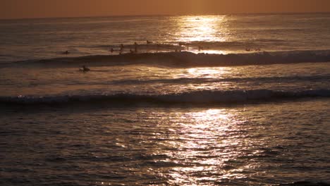 A-group-of-surfers-choosing-waves-at-sunset---SLOMO