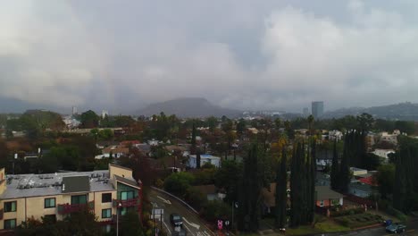 4K-Aerial-Drone-footage-of-Studio-City,-CA-with-rain,-cloudy-skies-and-a-rainbow