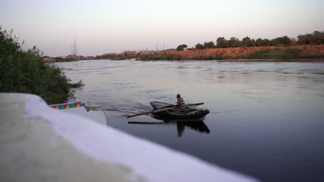 Río-Nilo-Egipto-Agricultor-Local-Remando-Durante-La-Puesta-De-Sol-Con-Un-Barco-Tradicional-De-Madera-Hecho-A-Mano