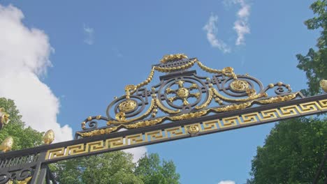 Slow-motion-footage-of-a-Royal-entrance-to-Summer-Garden,-Saint-Petersburg-with-golden-elements,-old-ornaments,-blue-sky