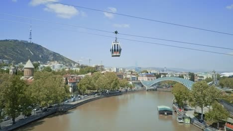 Tbilisi-aerial-view-on-a-funicular-over-Mt'k'vari-River,-autumn-view,-cars-passing-by,-old-town,-glass-bridge