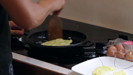 Man-cooks-egg-in-cast-iron-skillet