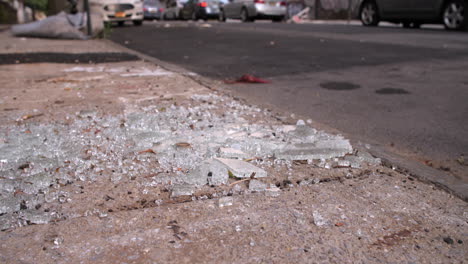Slider-shot-of-shattered-glass-on-a-city-street