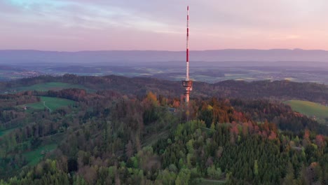 Aerial-drone-view-from-above-the-Bantiger-TV-tower-near-Berne-on-a-gorgeous-morning-with-dramatic-sunrise-colors-and-lush-mountain-views