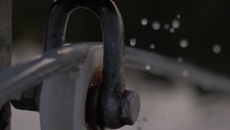 Close-up-blurry-mechanism-of-a-rotating-spinning-wheel-with-slow-motion-water-drops-falling
