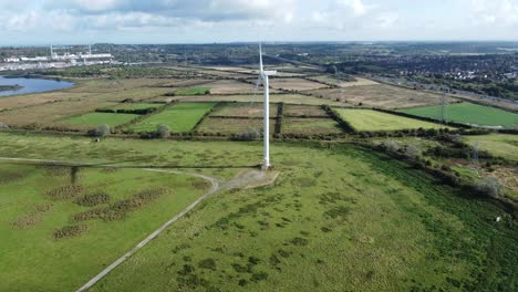 Aerial-view-flying-around-renewable-energy-wind-farm-wind-turbines-spinning-on-British-countryside-push-in