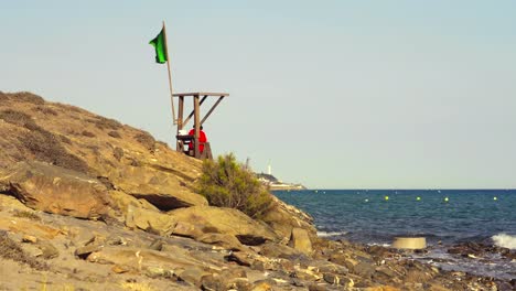 Small-lifeguard-watch-tower-with-a-green-flag
