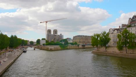Blick-Von-Der-Seine-Auf-Die-Restaurierung-Der-Kathedrale-Notre-Dame-De-Paris,-Die-Durch-Einen-Brand-In-Paris,-Frankreich,-Beschädigt-Wurde