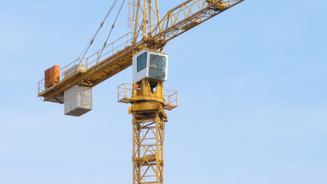 Worker-operates-fixed-jib-tower-crane-on-construction-site-in-wind