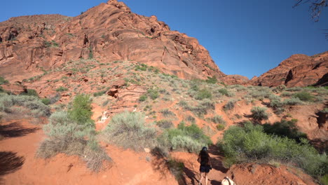 St-George-Hiking-Trail,-Utah-USA,-Slow-Motion-of-Young-Female-Hiker-Under-Red-Sandstone-Hills-on-Hot-Sunny-Day,-Full-Frame