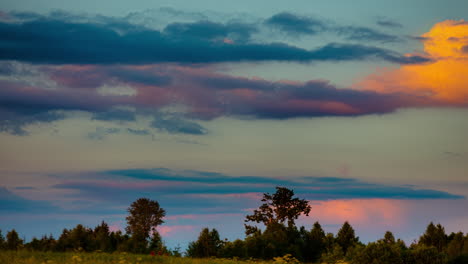 Cumulus-clouds-rolling-through-sky-changing-color-from-sunset-sunlight,-timelapse