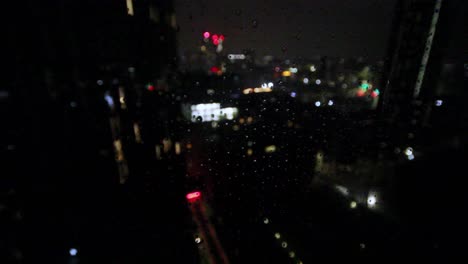 Rain-running-down-a-window-in-a-storm-in-the-city-of-manchester-,-city-defocused-and-in-the-background-,-water-drops-in-focus