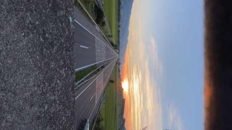 Vertical-time-lapse-video,-cars-driving-on-a-highway-while-sunset,-Switzerland