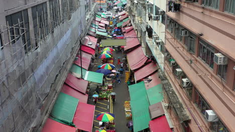 Overview-Of-Busy-Street-Lined-With-Food-Stalls-In-Hong-Kong-Under-The-Rain