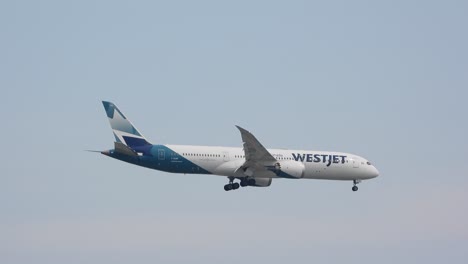 WestJet-airlines-airplane-preparing-for-landing,-dreary-day,-slow-pan-shot