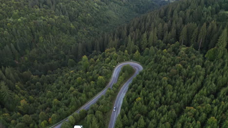 Aerial-tilt-down-over-mountain-road-hairpin-turn-over-Nyerges-Teto,-Romania