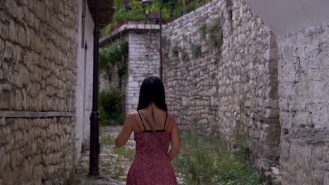 Young-female-tourist-walking-through-Mediterranean-stone-village
