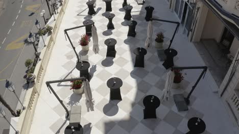 Aerial-View-Of-Cocktail-Tables-On-Tiled-Balcony-Of-Hotel-On-A-Sunny-Day-In-Croatia