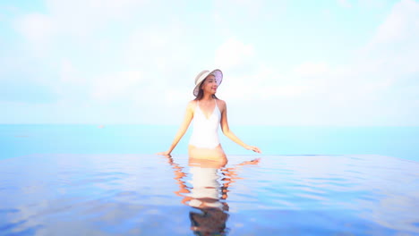 Sitting-on-the-edge-of-an-infinity-pool-makes-this-young-and-attractive-woman-look-as-if-she-is-floating-on-top-of-the-water