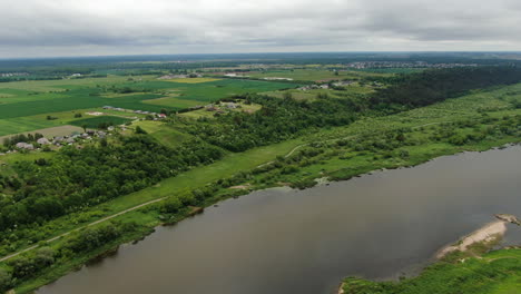Lebendiges-Flusstal-In-Litauen-An-Bewölkten-Tagen-Mit-Kleinen-Wohngebäuden-Am-Hang,-Luftbild