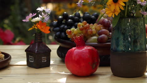Gartentisch-Mit-Schale-Mit-Frischen-Weintrauben,-Rotem-Granatapfel-Und-Baklava-Im-Garten