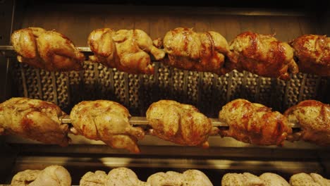 Chicken-On-The-Turning-Spit-With-Tasty-Golden-yellow-Roasted-Skin-In-Four-Rows---slow-motion
