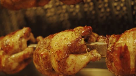 -Grilled-Whole-Chickens-With-Tasty-Golden-yellow-Roasted-Skin-On-A-Turning-Spit-In-A-Row---close-up,-slow-motion