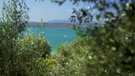 Wide-establishing-shot-of-boats-in-the-lake,-on-Jamaica-Beach,-Sirmione,-Lago-Garda,-Lake-Garda,-Italy