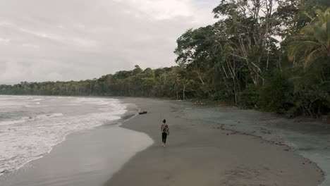 Playa-Larga-Y-Arenosa-Con-Mujer-Caminando-En-Playa-Punta-Mona,-Costa-Rica