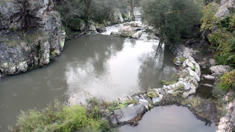 Ruhiges-Flusswasser-Mit-Reflexionen,-Die-Durch-Felsen-In-Portugal-Fließen---Hochwinkelaufnahme