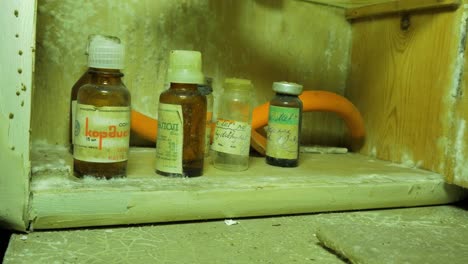 Old-medical-bottles,-accessories-inside-the-abandoned-Soviet-underground-bomb-shelter,-old-Soviet-Cold-war-bunker,-apocalypse,-close-up-handheld-shot