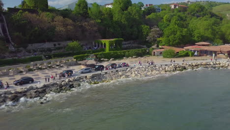 Drone-shot-of-people-walking-near-coastline-of-Black-Sea-and-Balchik-Palace