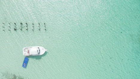 AERIAL---Boat-on-clear-turquoise-waters,-Cayo-Icacos,-Puerto-Rico,-top-down-truck-left
