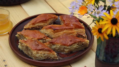 Homemade-baklava-on-table-next-to-bottle-with-flowers