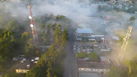 Jarabacoa-Luftaufnahme,-Stadt-Bedeckt-Mit-Intensivem-Nebel-Am-Morgen,-Atemberaubende-Umgebung-Einer-Kleinen-Stadt-In-Der-Dominikanischen-Republik-Mit-Bäumen-Und-Bergen-Hinter-Der-Stadt,-Verträumte-Landschaft