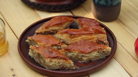 Plate-full-of-baklava-on-table-next-to-red-pomegranate
