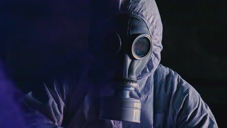 Adult-In-White-Hazmat-Suit-Wearing-Face-Respirator-Surrounded-By-Purple-Smoke
