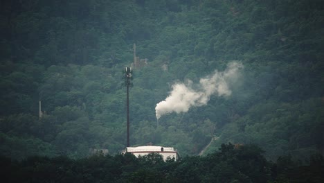 A-factory-near-a-mountain-range_produce-a-white-smoke_wide-shot_long-shot_50fps